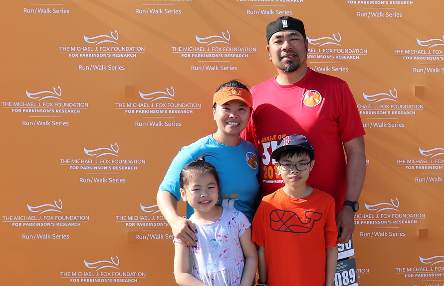 family standing against MJFF backdrop