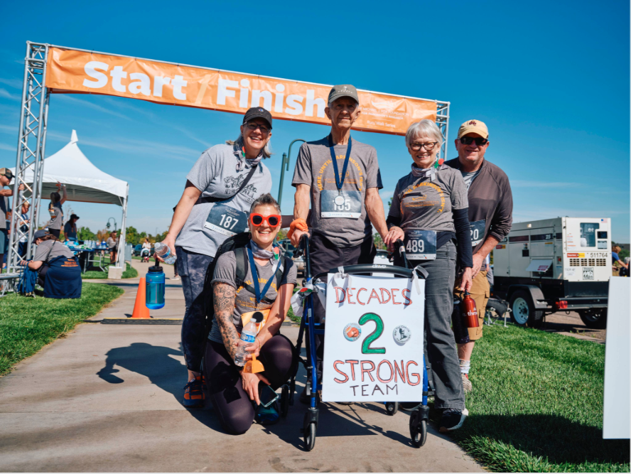 A group of participants from a Run/Walk smiling at the finish line.