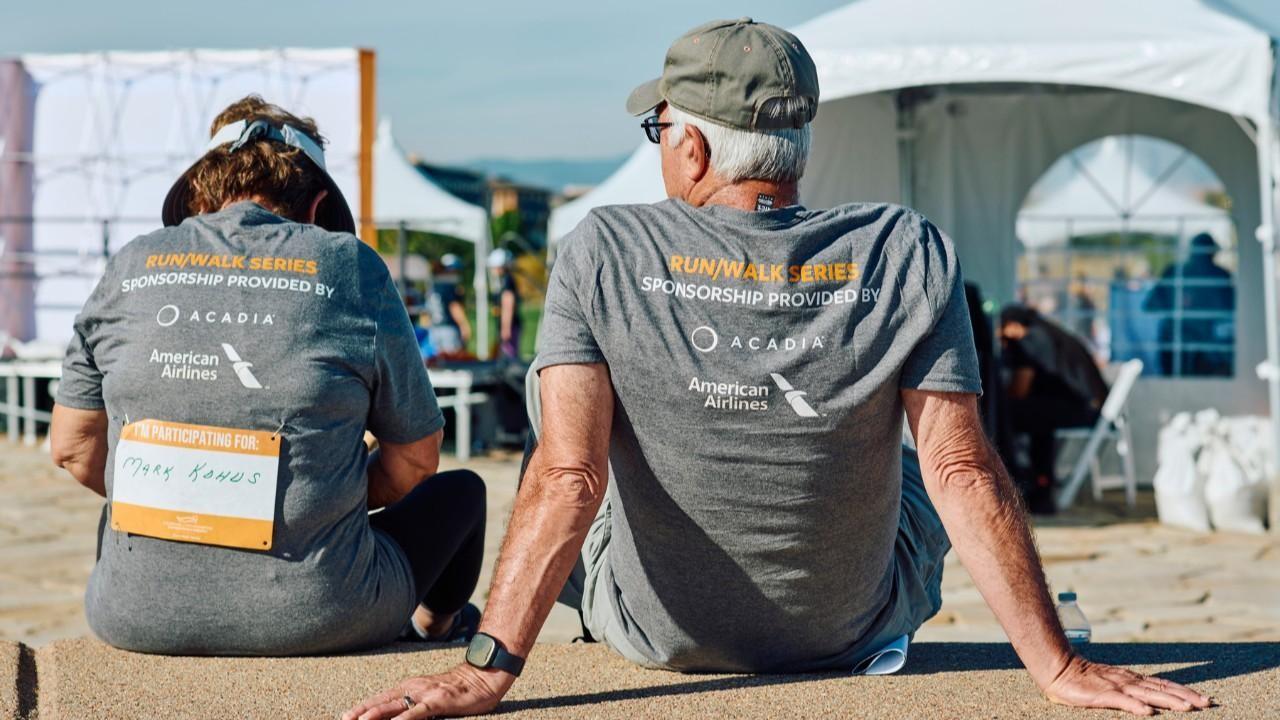 A couple sitting on the ground after participating in a Run/Walk