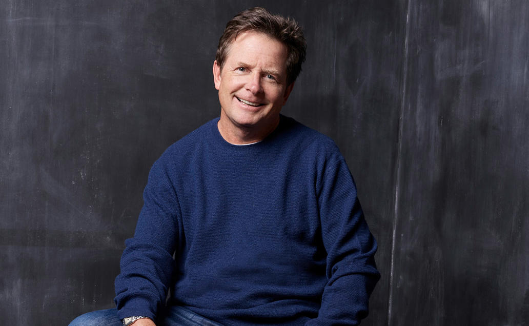 Michael J. Fox in blue sweater posing for the camera.