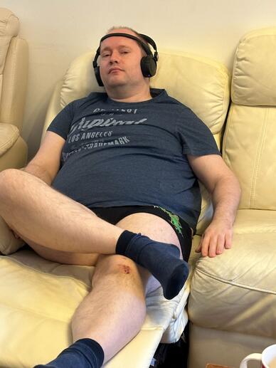 Wojciech Wasilewski sitting on a couch with headphones.