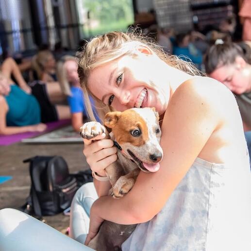 A woman holding a dog and smiling