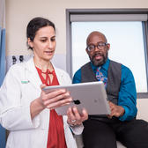 Doctor looking at iPad with patient