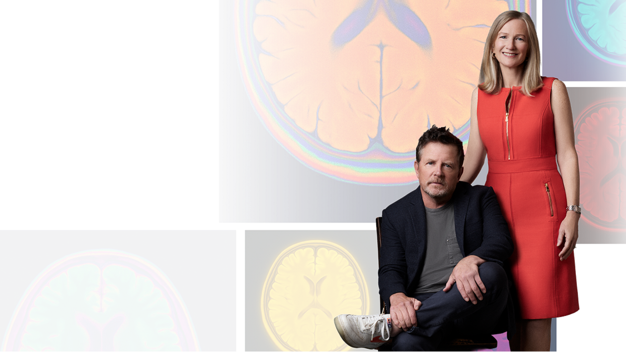 Michael J. Fox and Co-Founder and CEO Deborah W. Brooks in front of a background of brain scan imageas