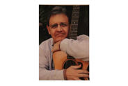Person with Parkinson's Mark Robinson holding his guitar.