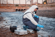 Person tests water for chemical contamination.