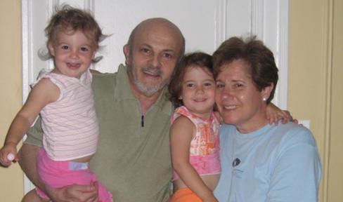 Two young children and older adults smiling at the camera.