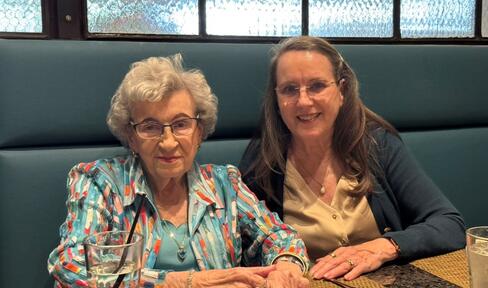 Celia and Pat sitting together in a booth.