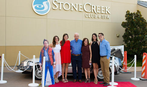 The Dastugue family posing in front of a DeLorean.