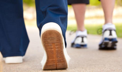 Two people wearing sneakers walking.