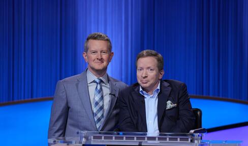 Harvey seated next to 'Jeopardy!' show host Ken Jennings. 