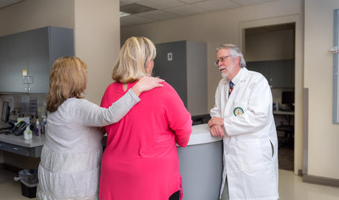 Three people talking at a clinic