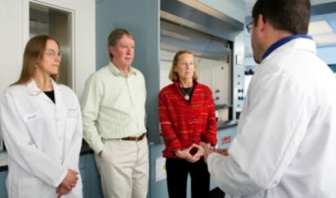 Researchers talking with couple in lab.