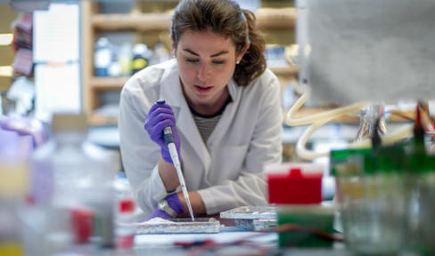 Female researcher pipetting in the lab.