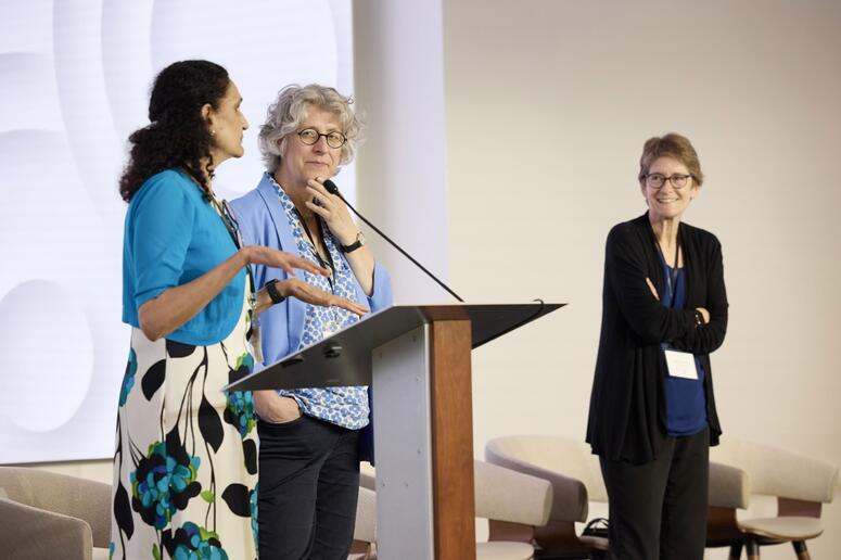 Three women present at a podium.