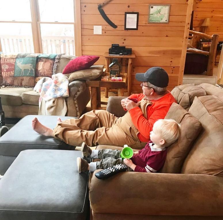 Chip and Teddy watch TV together on the couch.