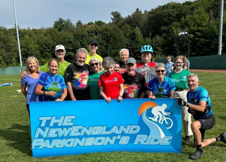 The team poses with the New England Parkinson's Ride sign.