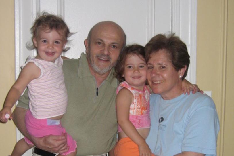 Two young children and older adults smiling at the camera.