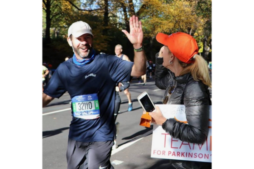 Gary gets a high five from Susie as he passes the Team Fox cheer zone at the 2018 New York City Marathon.