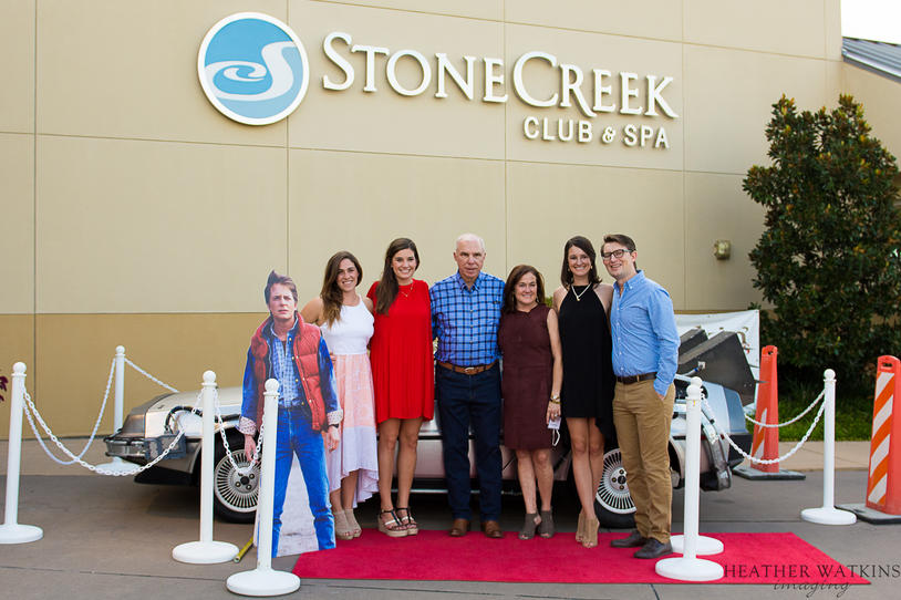 The Dastugue family posing in front of a DeLorean.