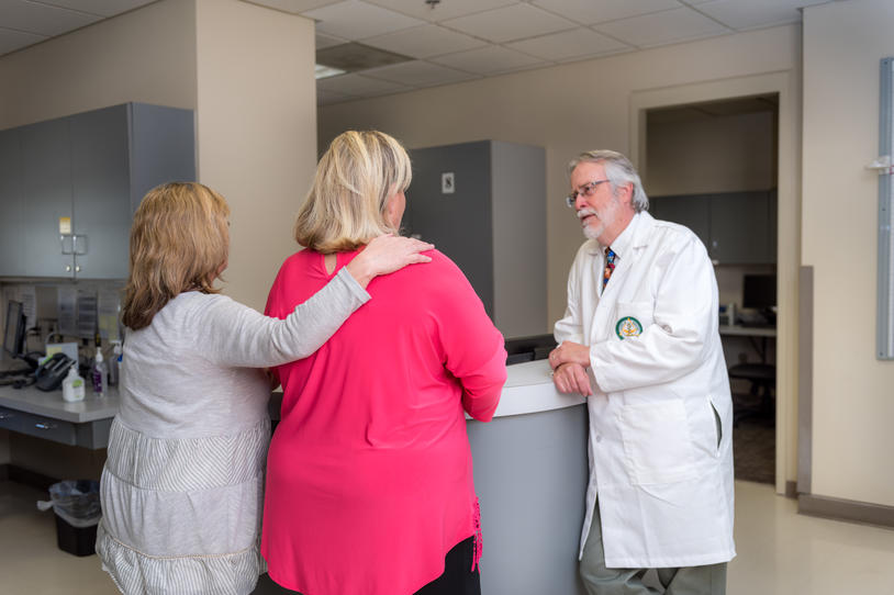 Three people talking at a clinic