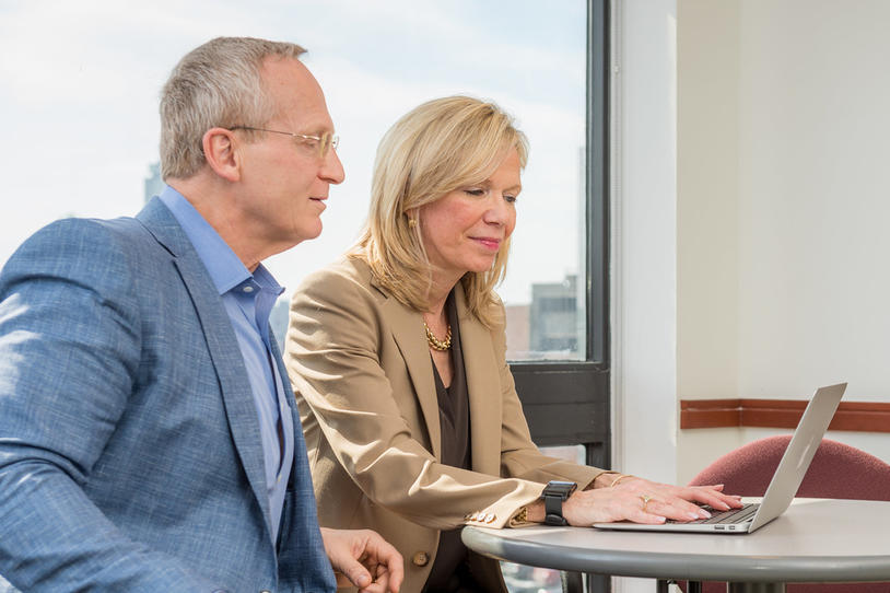 Man and woman sitting at a table with a laptop