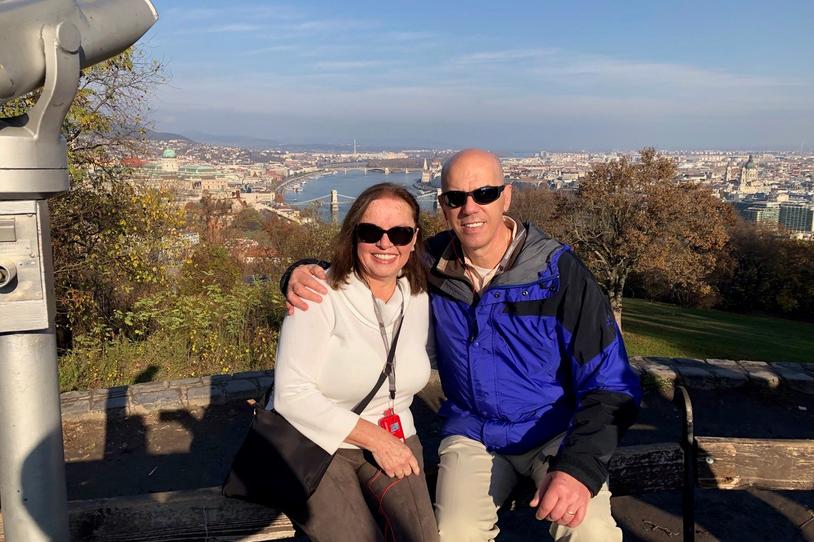 Two people smiling at the camera outside.