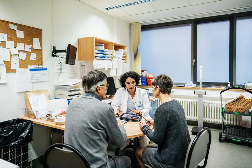 Three people talking at a clinic