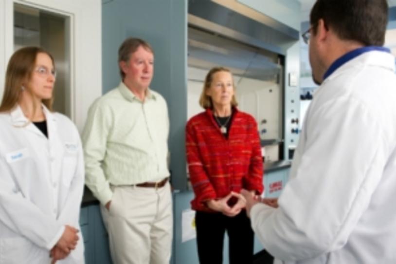 Researchers talking with couple in lab.