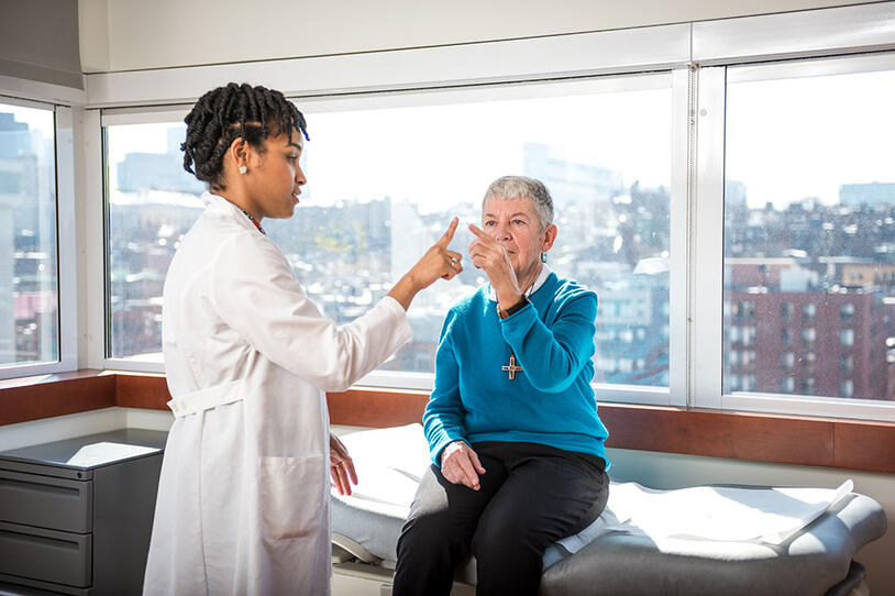 A doctor checks a patient in an office overlooking a city.