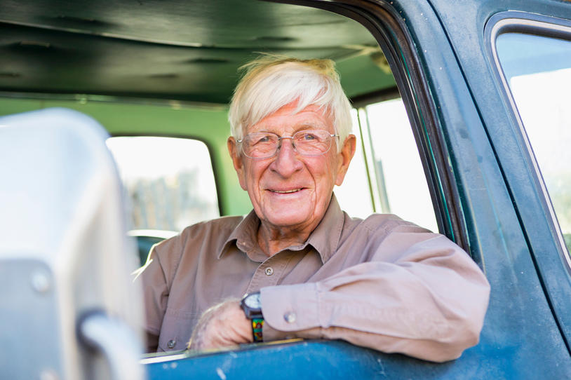 Older man sitting in the front seat of his truck.