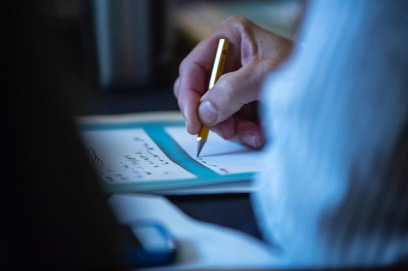 Close-up of someone writing with a pencil