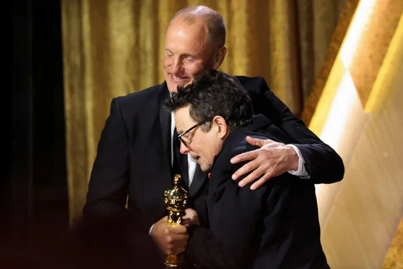 Actor Woody Harrelson congratulates Michael J. Fox, winner of the Jean Hersholt Humanitarian Award, onstage during the Governors Awards. Photo credit: Kevin Winter/Getty Images