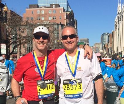 Two male runners posing for the camera at the Boston marathon.