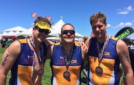 Three men posing for the camera at a Team Fox event.