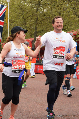 Male and female runners holding hands at a Team Fox event.