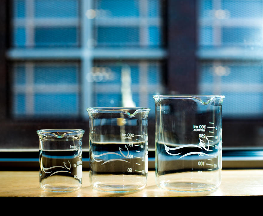 Three beakers with MJFF logo on table.