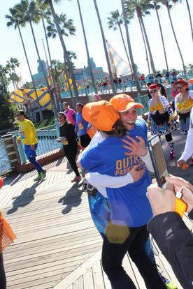 Two female attendees hugging at an MJFF Fox Trot event.