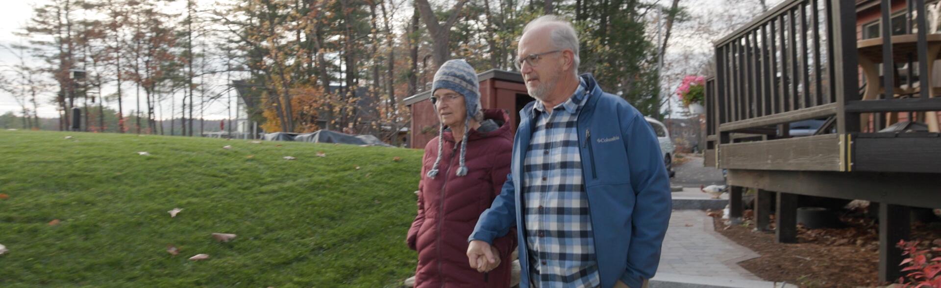 man and woman walking outside holding hands
