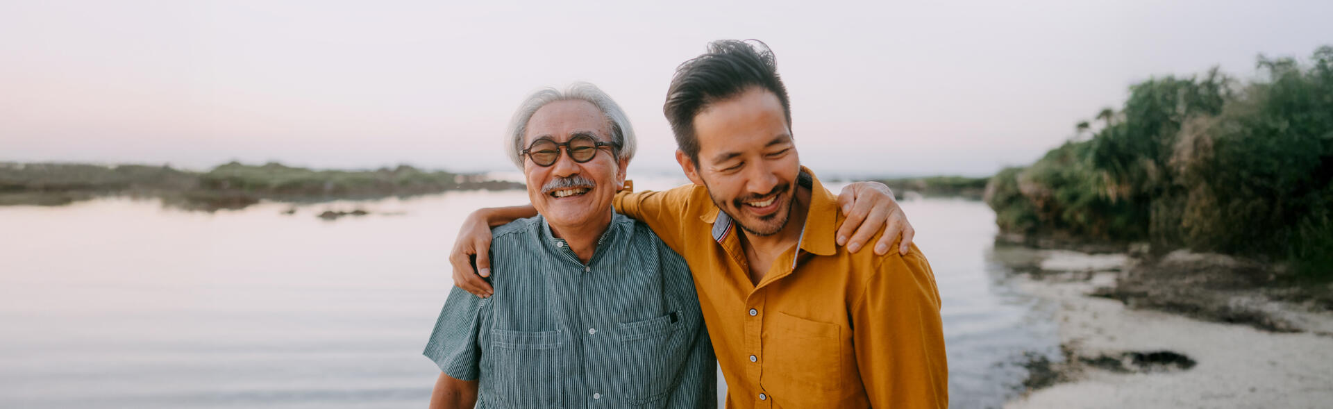 An older man and younger son hugging