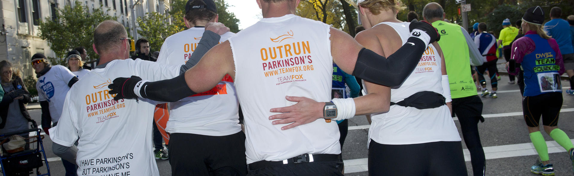Team Fox marathon runners embracing on course.