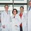 Doctors in white coats smiling.
