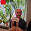 Wojciech Wasilewski smiling and holding a copy of his book in Polish.