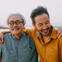 An older man and younger son hugging