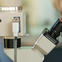 Female researcher looking through a microscope in the lab.