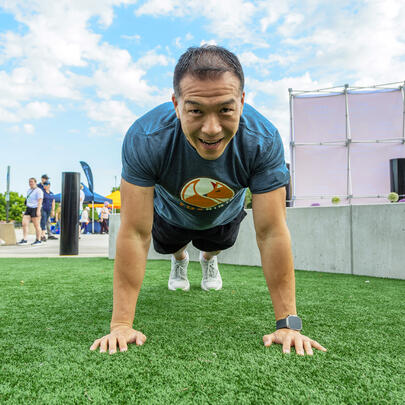 Man preparing to do a push up on grass