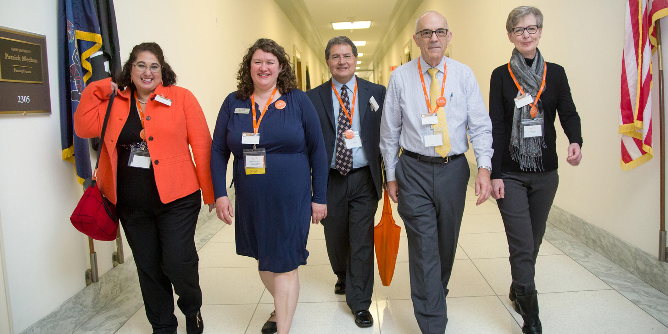 Israel Robledo and four others walk down a hallway in a legislative building