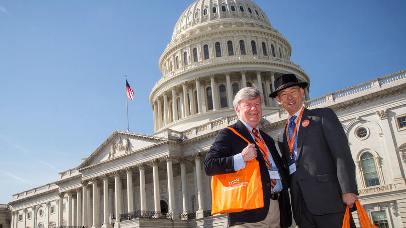 Two male advocates in front of the United States Capitol building at the Parkinson's Policy Forum.